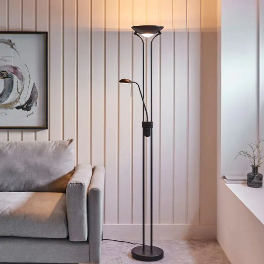 Modern floor lamp in a living room setting with a sofa and artwork on the wall.